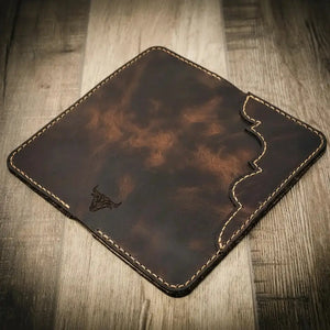 Brown full-grain leather long wallet with stitched edges and a bull logo.