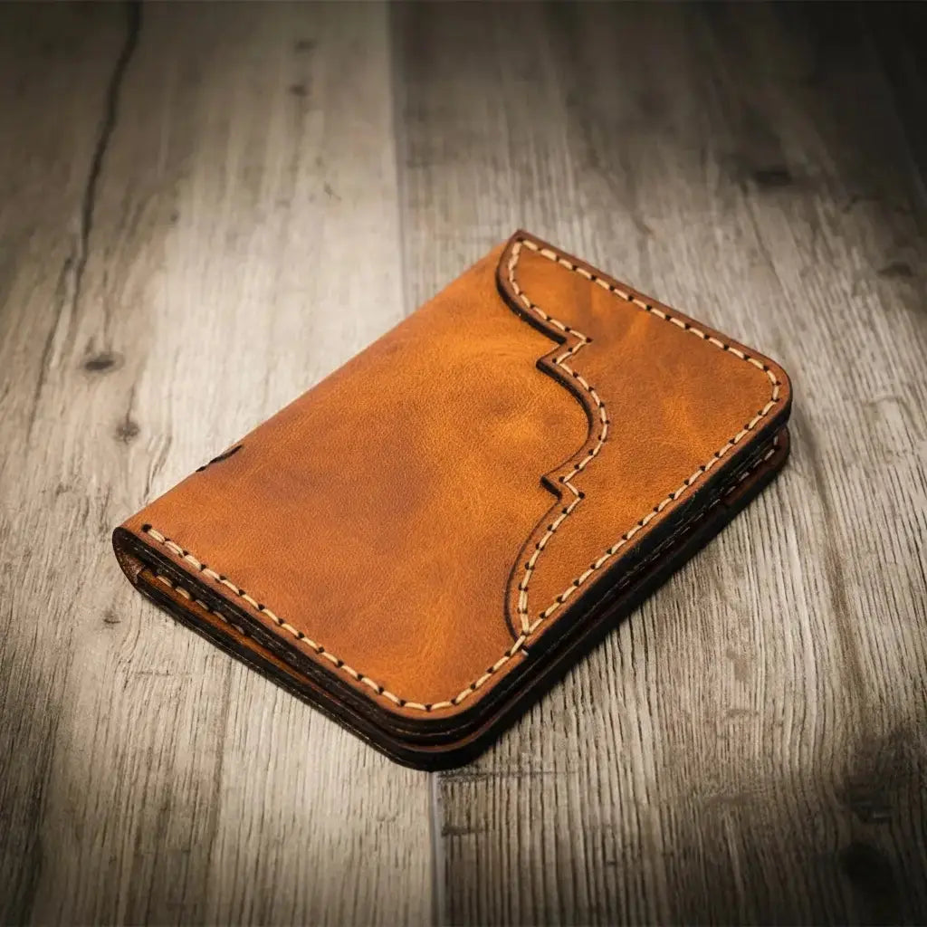 Brown leather bifold wallet with decorative stitching on a wooden background.