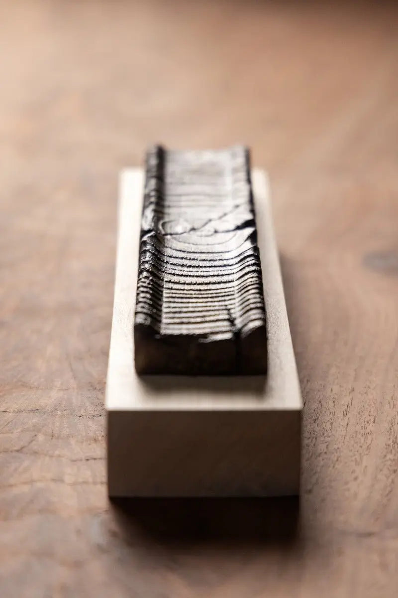 Urban wood incense holder with bronze detail on wooden base. Handmade home fragrance accessory for calming space.