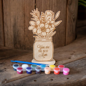 Wooden "You Are the Best Mom" painting kit with paints and brushes on a table.