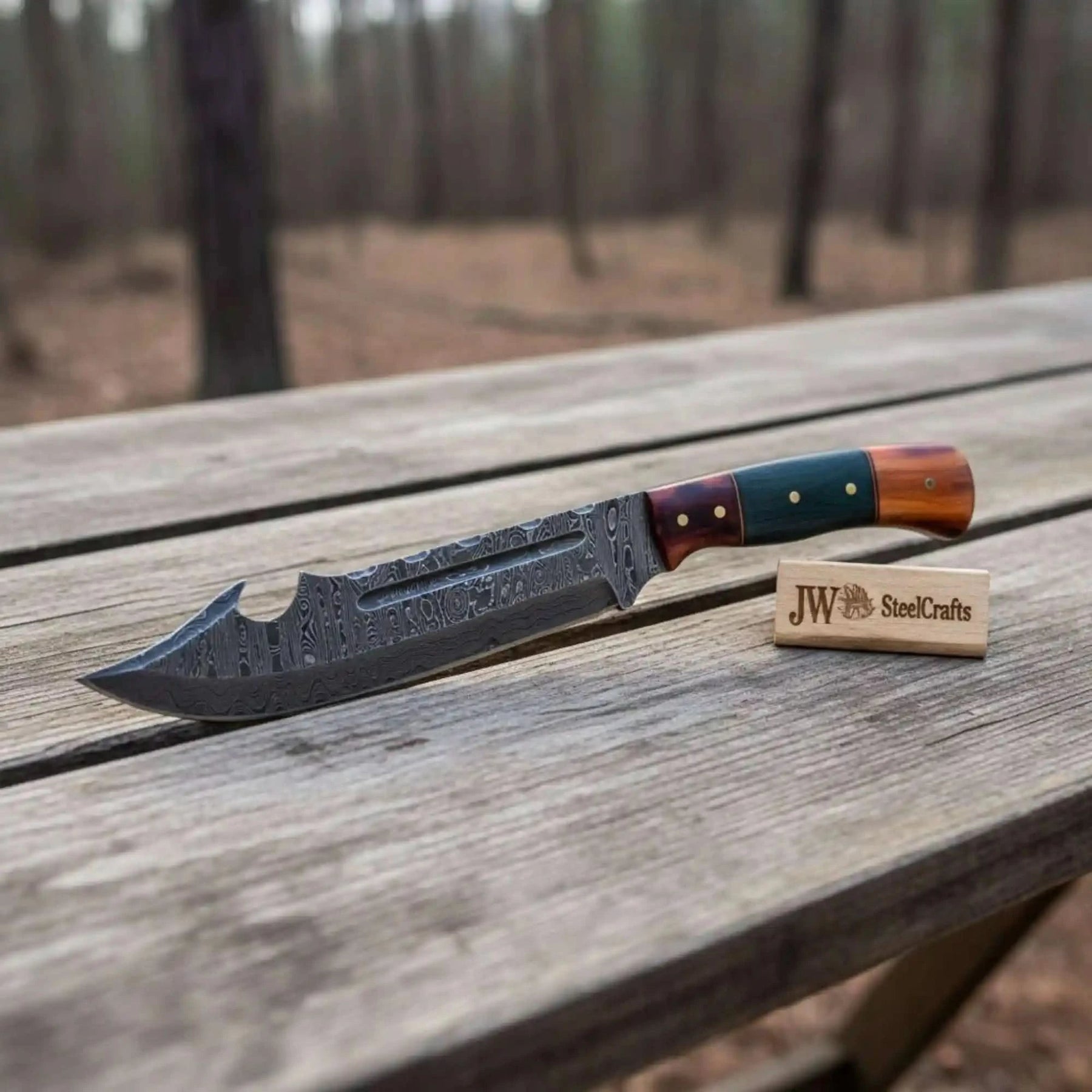 Handmade damascus steel knife with bone handle on dark surface