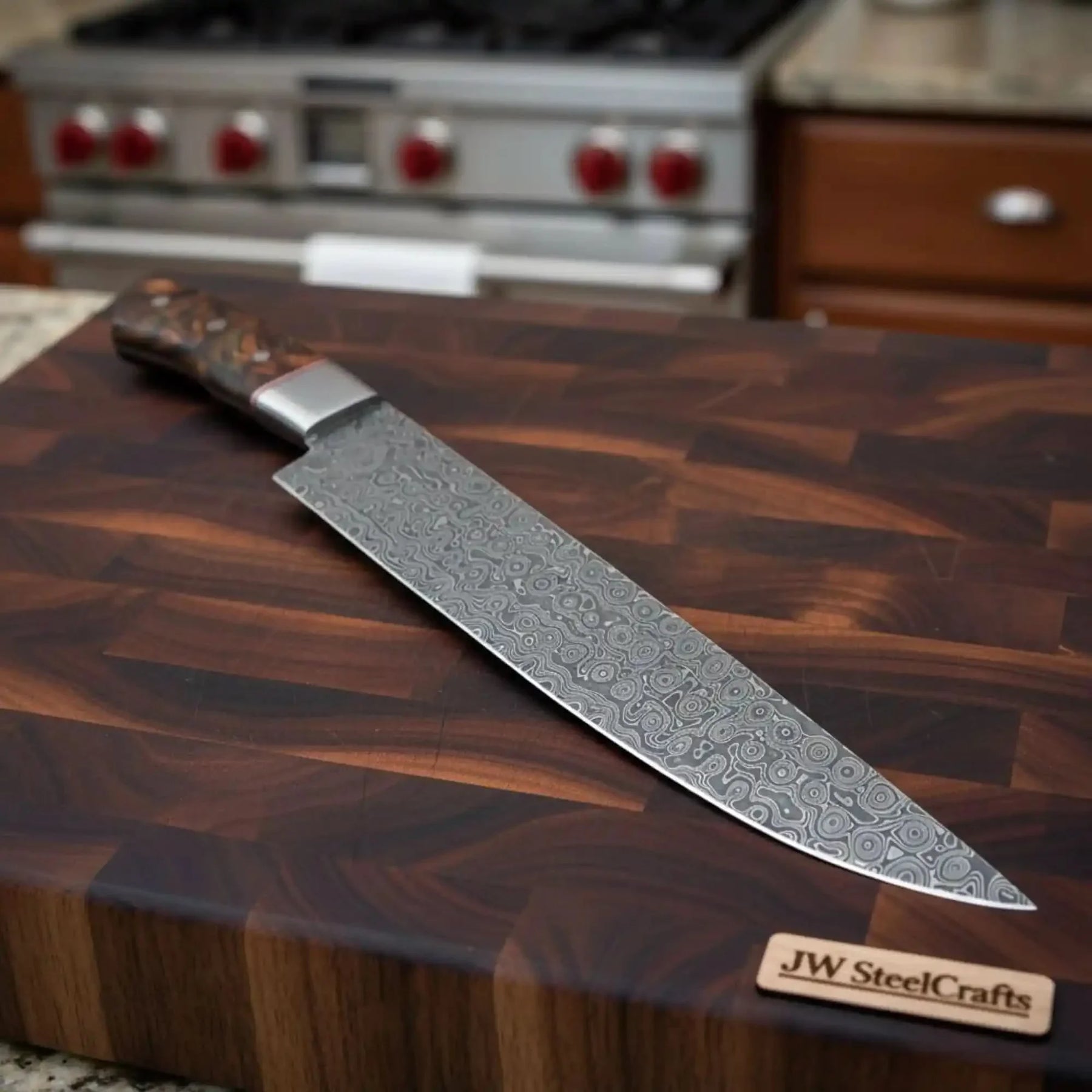 Handmade damascus steel knife with wood handle on dark surface