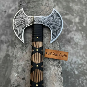 Damascus steel axe head with leather handle on rustic wood surface