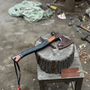 Damascus steel axe head with leather handle on rustic wood surface