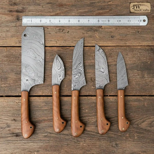 Handmade damascus steel knife with wood handle on dark surface