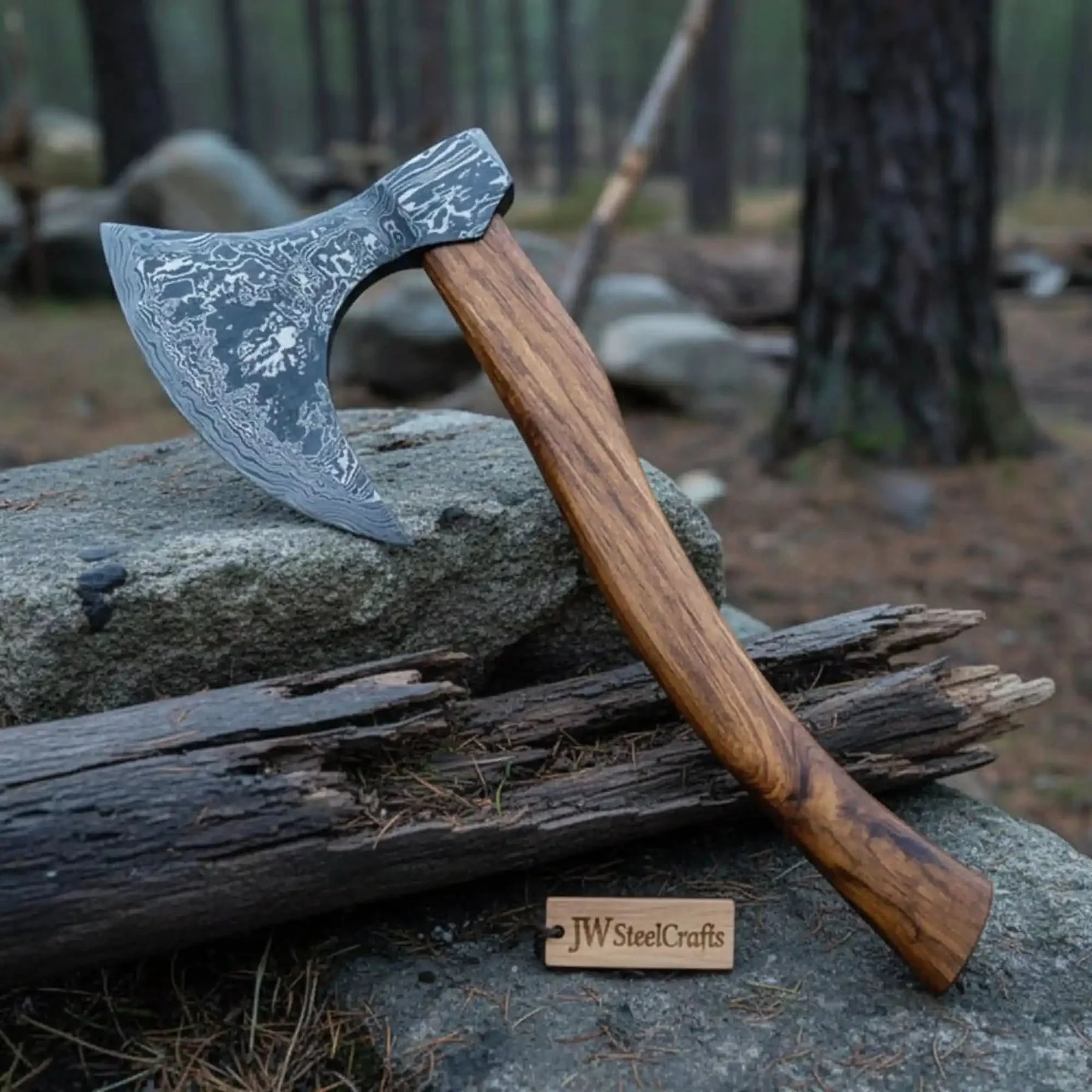 Damascus steel axe head with premium handle on rustic wood surface