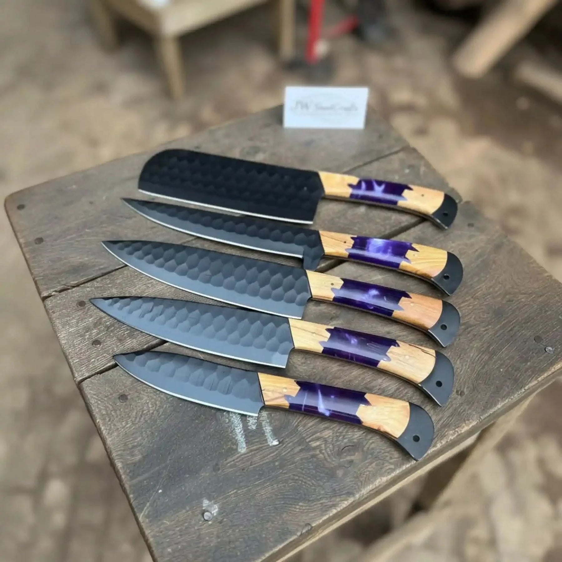 Handmade damascus steel knife with wood handle on dark surface