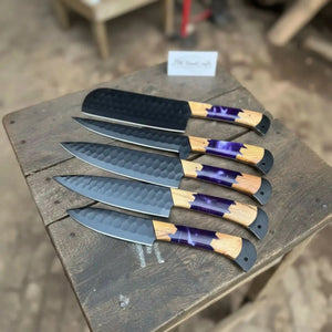 Handmade damascus steel knife with wood handle on dark surface