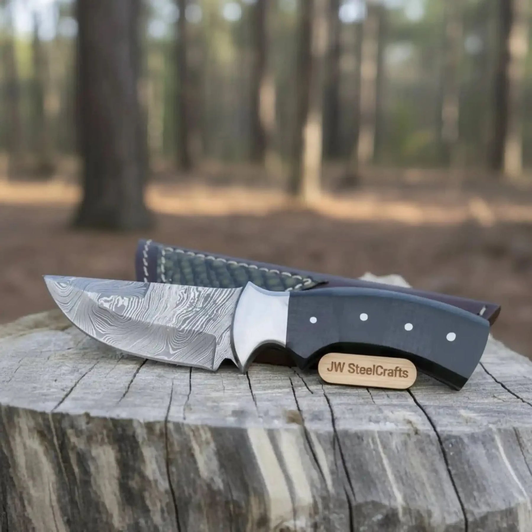 Handmade damascus steel knife with micarta handle on dark surface