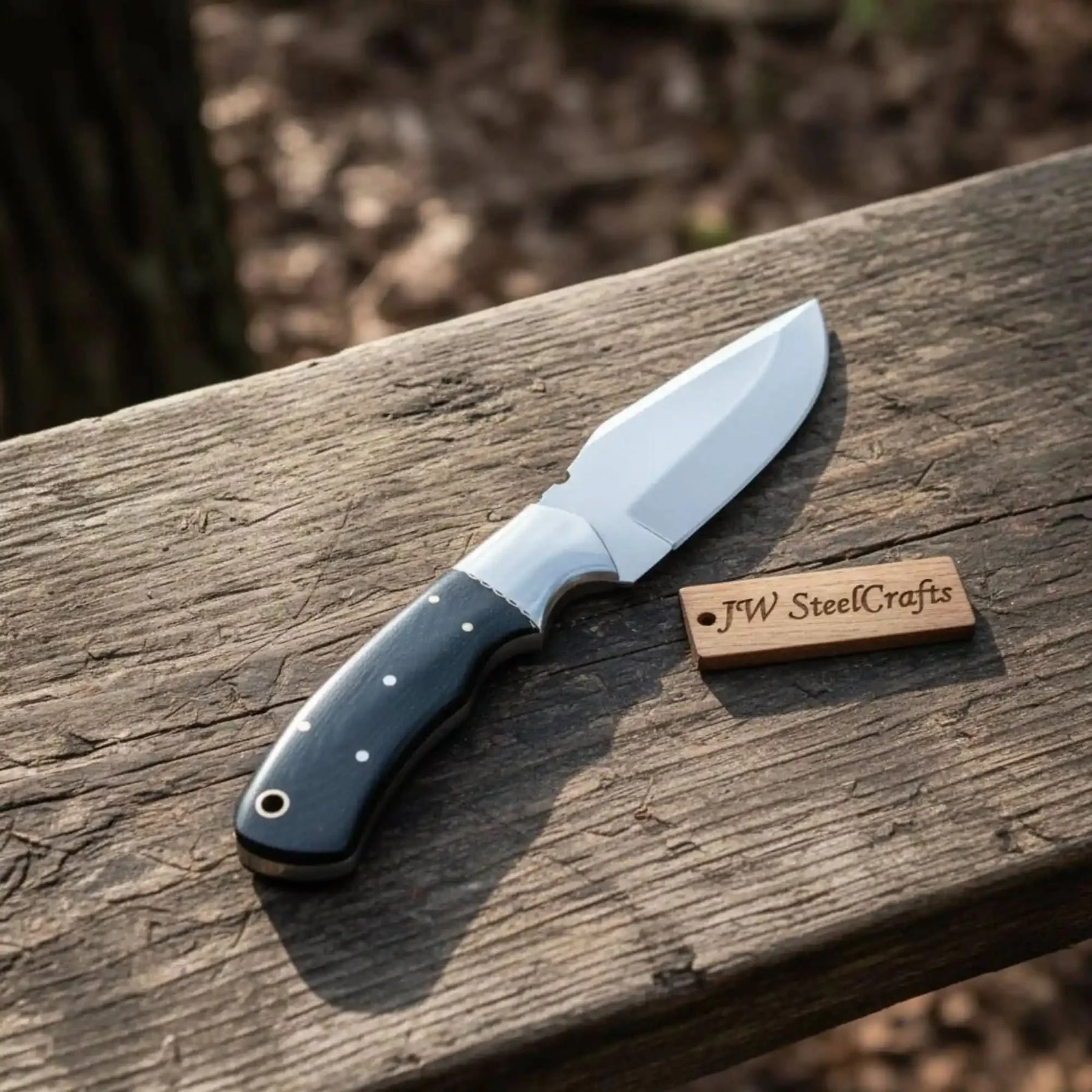 Handmade stainless steel steel knife with micarta handle on dark surface