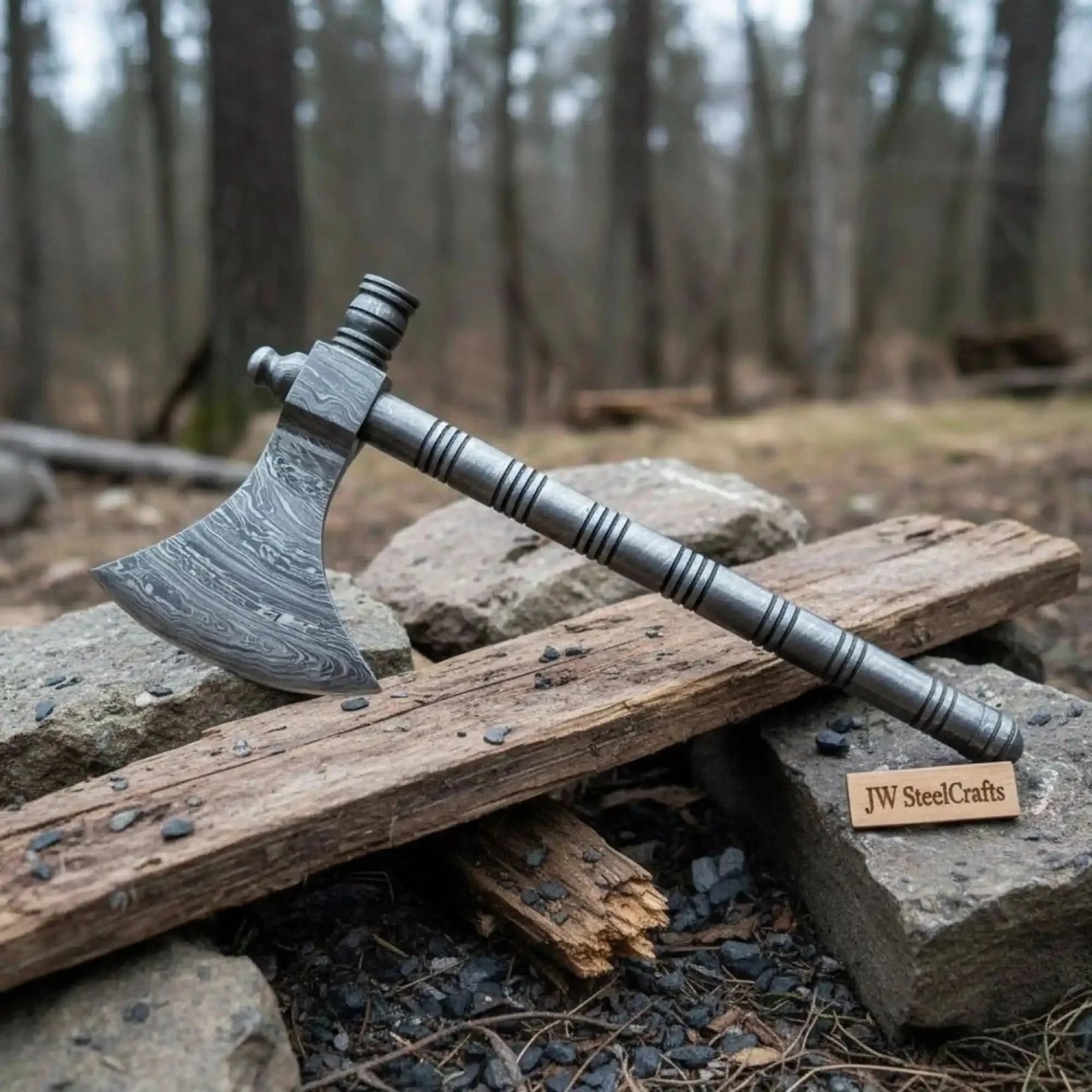 Damascus steel axe head with wood handle on rustic wood surface
