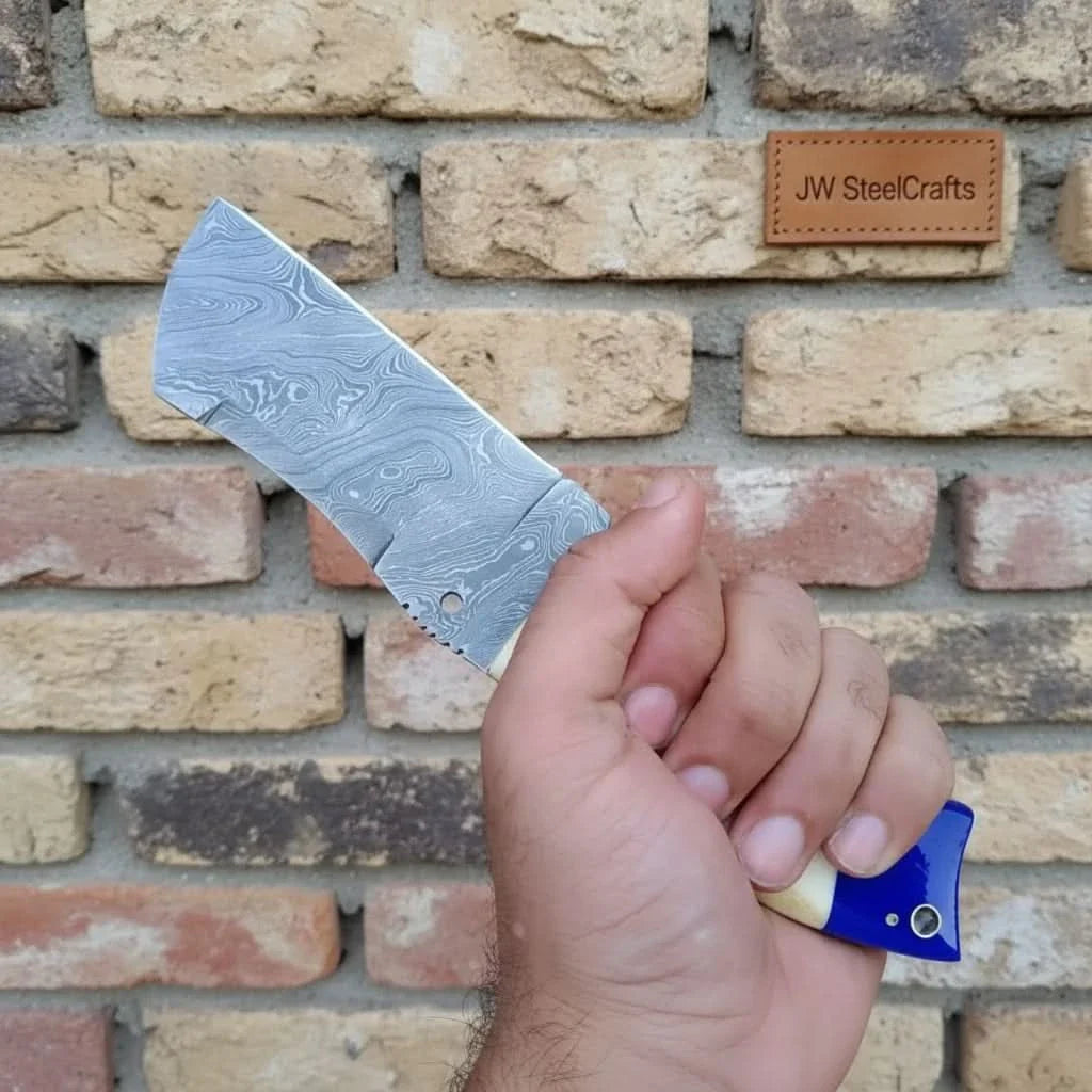 Handmade damascus steel knife with bone handle on dark surface
