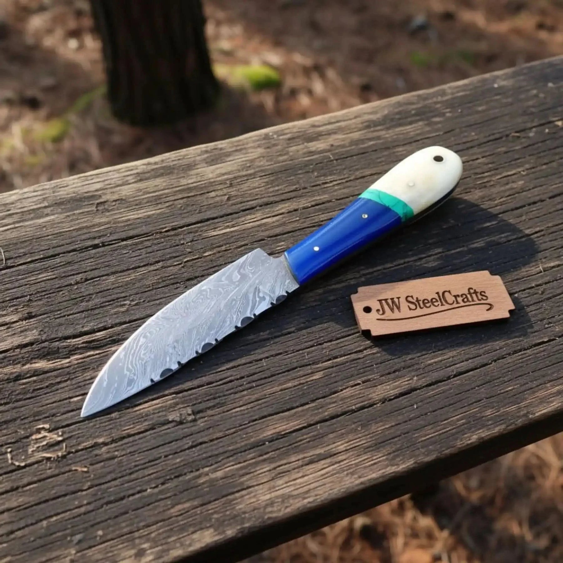 Handmade damascus steel knife with premium handle on dark surface