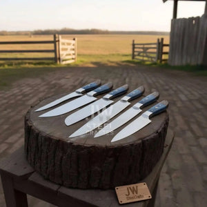 Handmade damascus steel knife with wood handle on dark surface