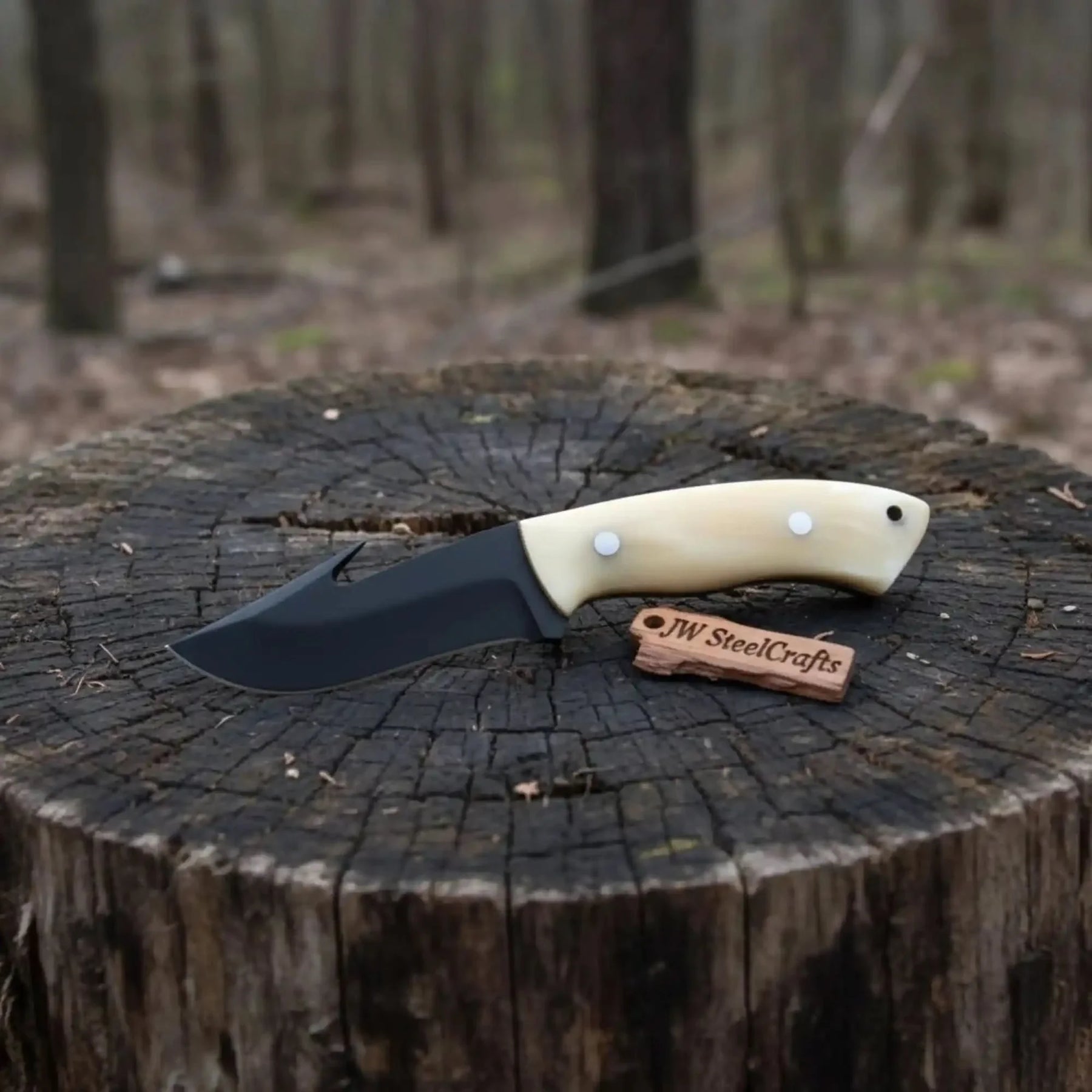 Handmade damascus steel knife with bone handle on dark surface