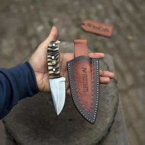 Handmade stainless steel steel knife with wood handle on dark surface