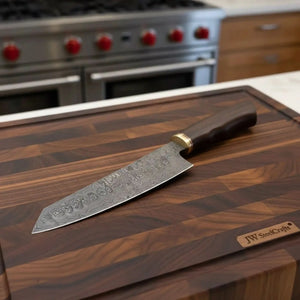 Handmade damascus steel knife with wood handle on dark surface
