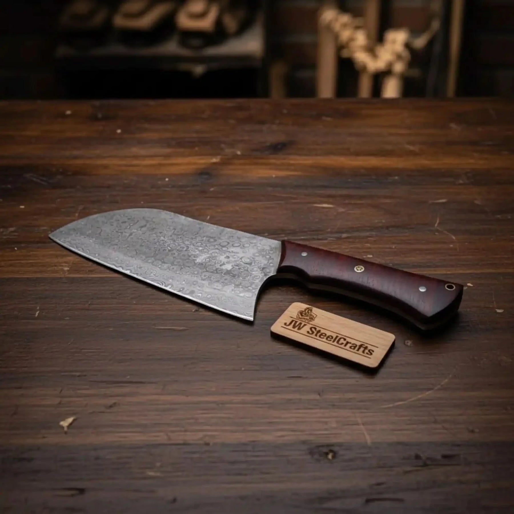 Handmade damascus steel knife with wood handle on dark surface