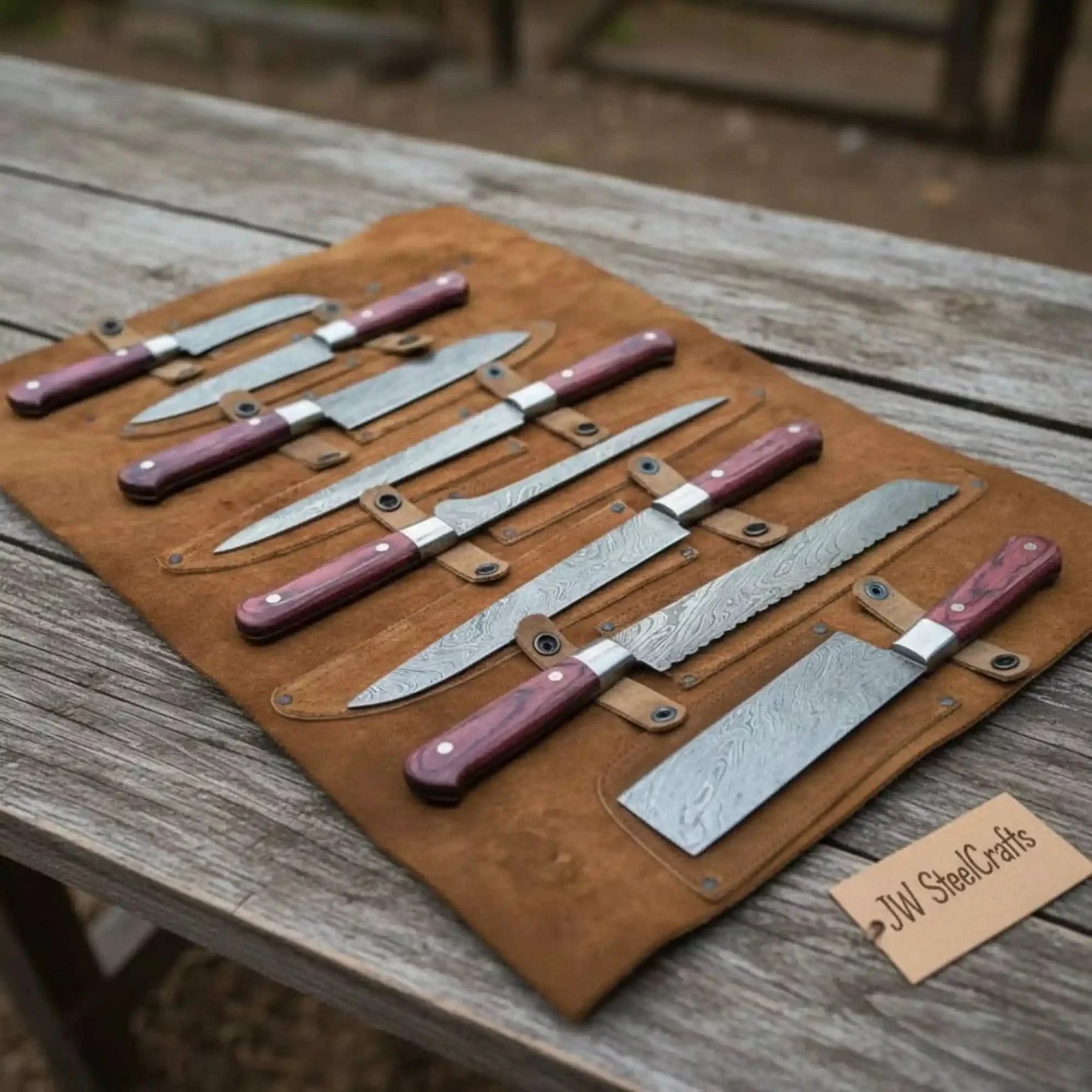 Handmade damascus steel knife with wood handle on dark surface