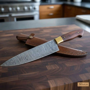 Handmade damascus steel knife with wood handle on dark surface