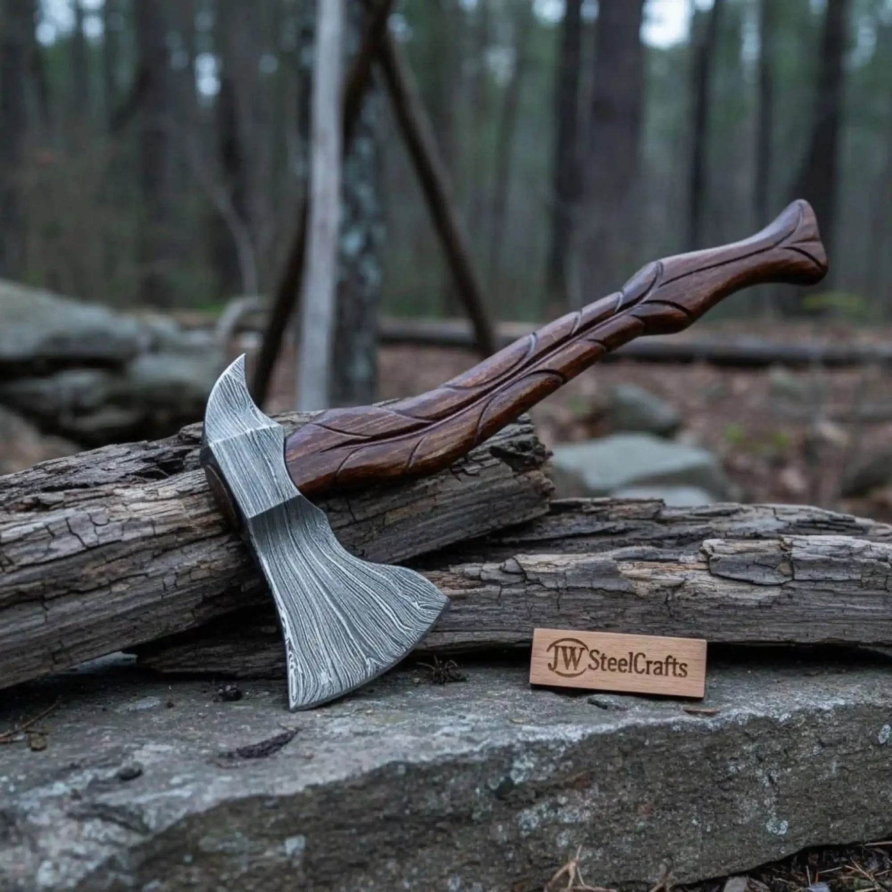 Damascus steel axe head with premium handle on rustic wood surface