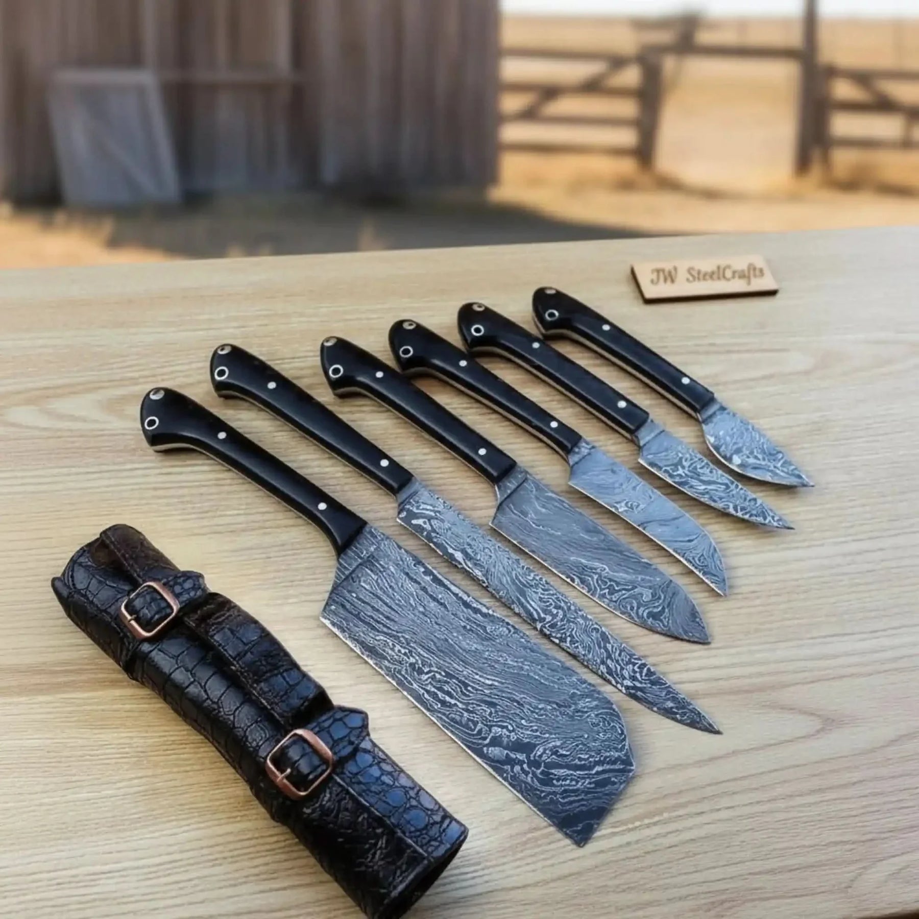 Handmade damascus steel knife with premium handle on dark surface