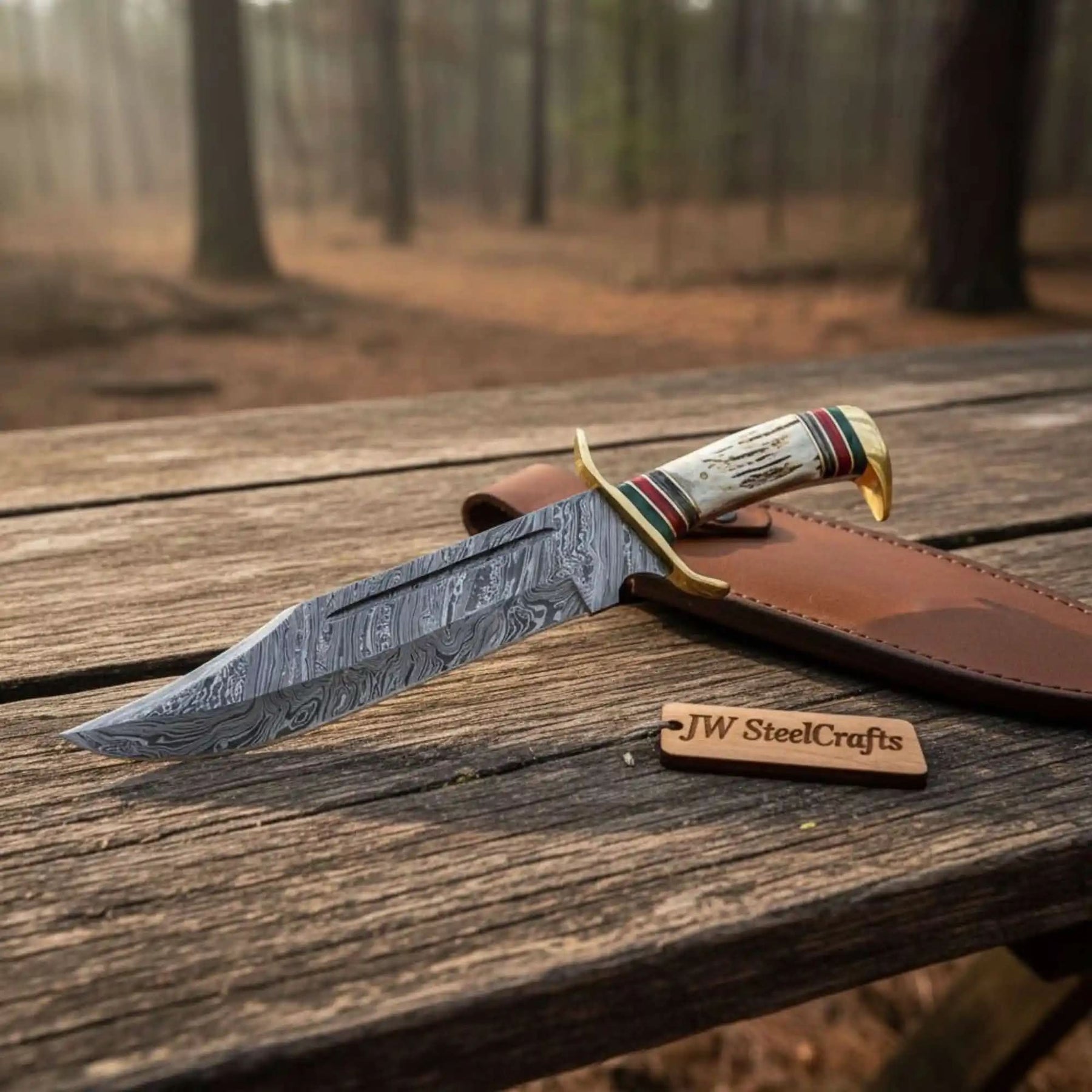 Handmade damascus steel knife with horn handle on dark surface