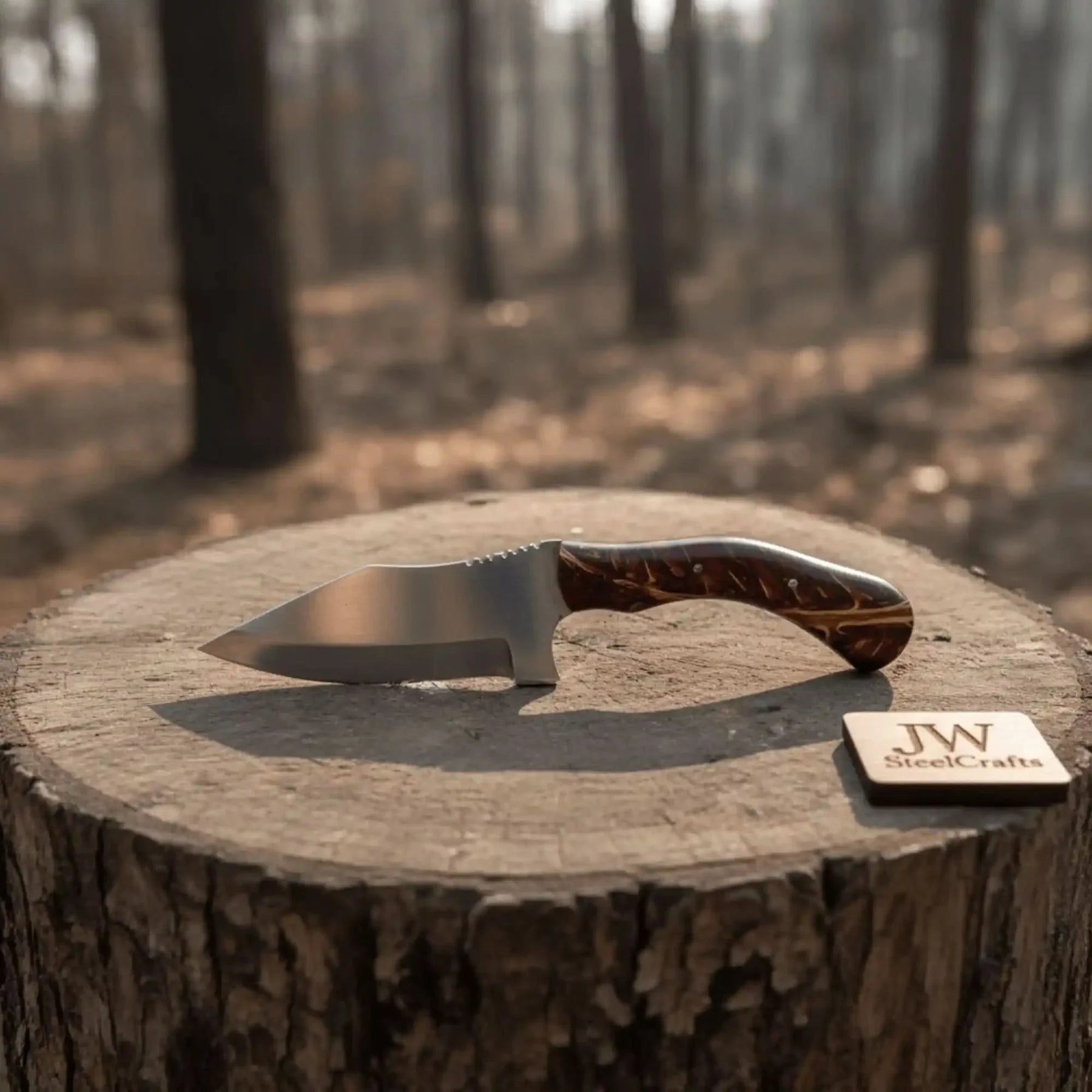 Handmade stainless steel steel knife with resin handle on dark surface