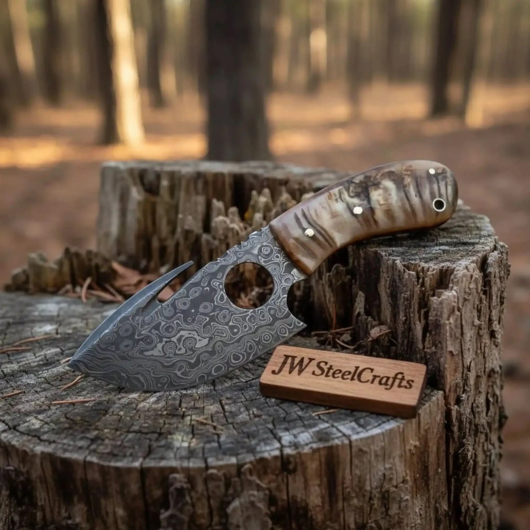 Handmade damascus steel knife with premium handle on dark surface