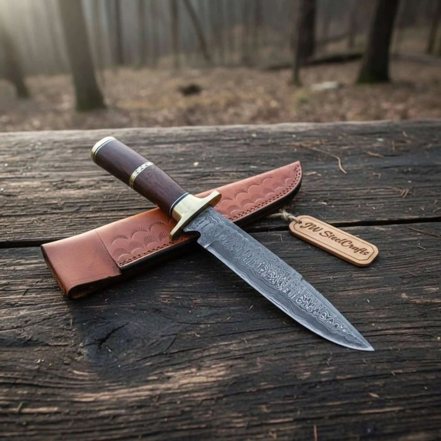 Handmade damascus steel knife with wood handle on dark surface