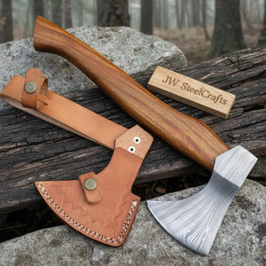 Damascus steel axe head with wood handle on rustic wood surface