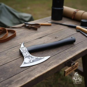 Damascus steel axe head with premium handle on rustic wood surface