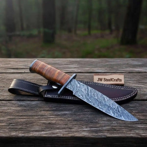 Handmade damascus steel knife with premium handle on dark surface