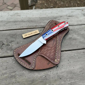 Handmade damascus steel knife with leather handle on dark surface