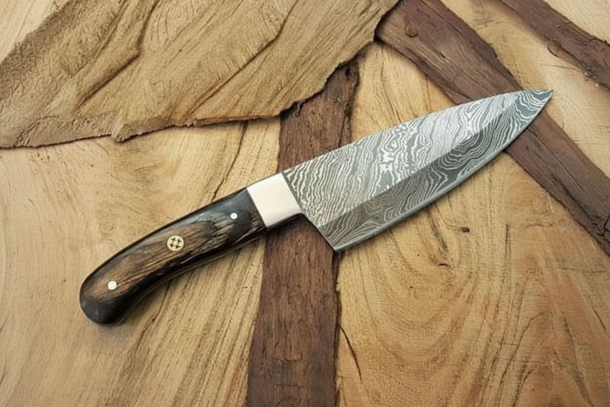 Handmade damascus steel knife with premium handle on dark surface