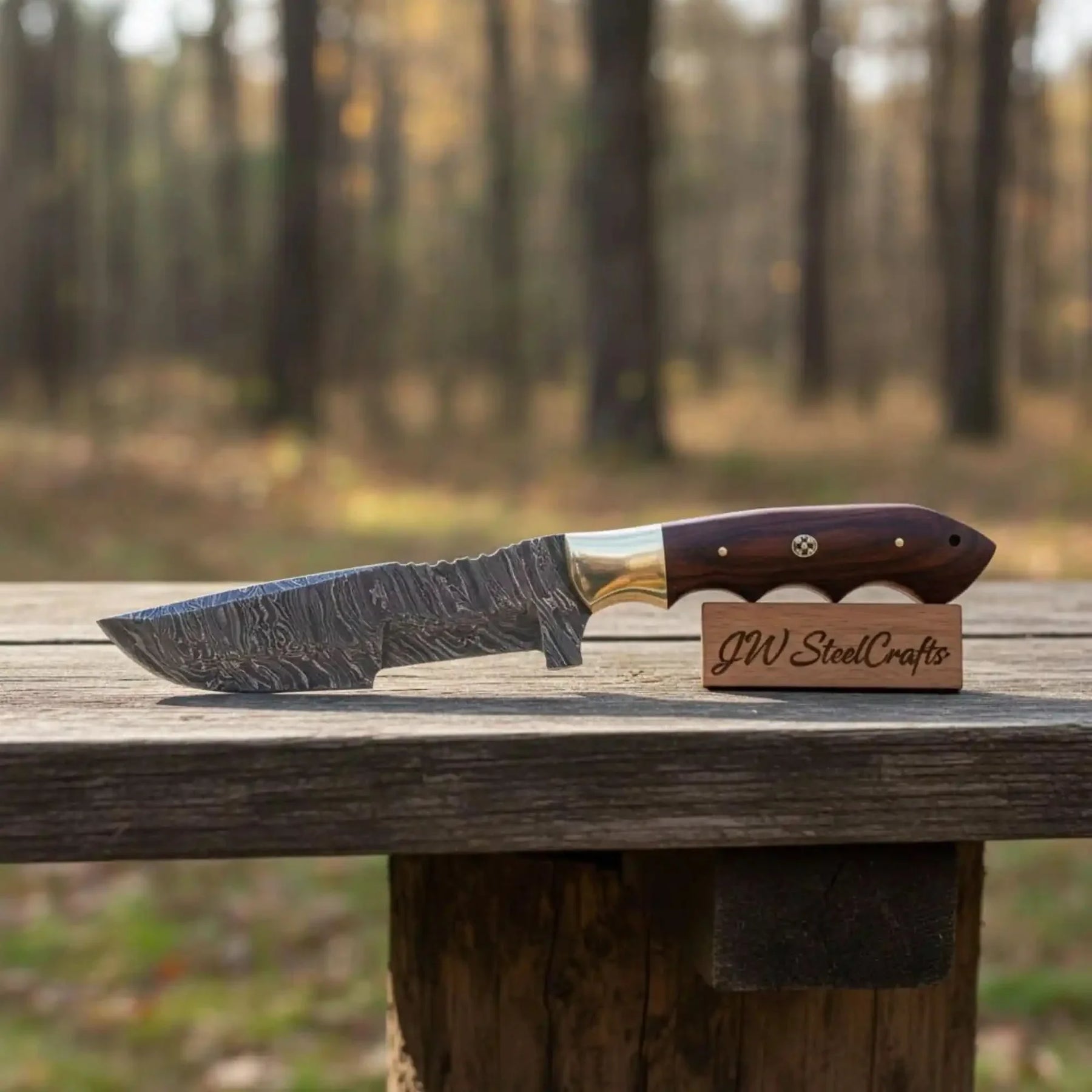 Handmade damascus steel knife with premium handle on dark surface