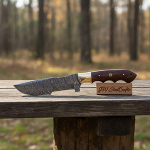 Handmade damascus steel knife with premium handle on dark surface