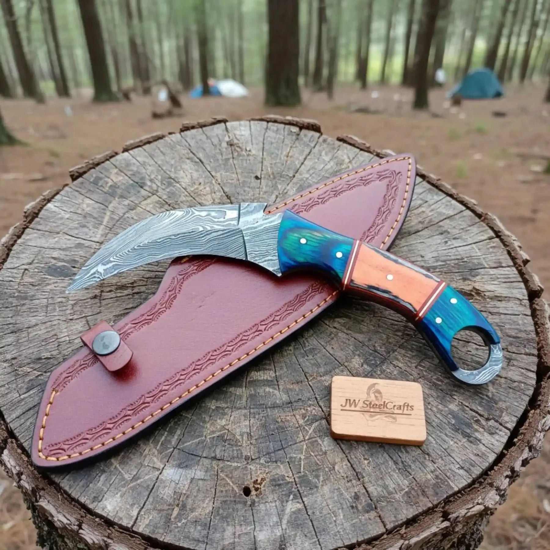 Handmade damascus steel knife with premium handle on dark surface