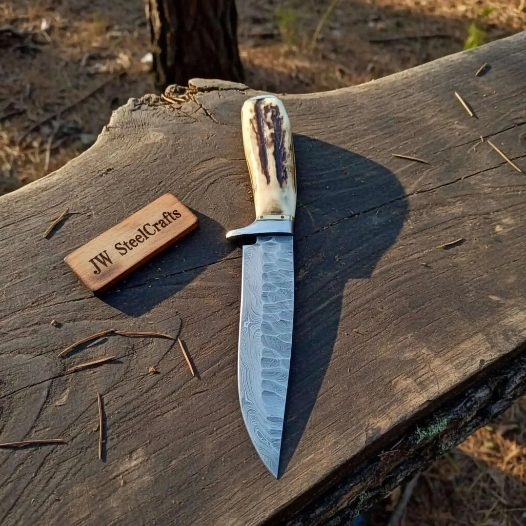 Handmade damascus steel knife with premium handle on dark surface