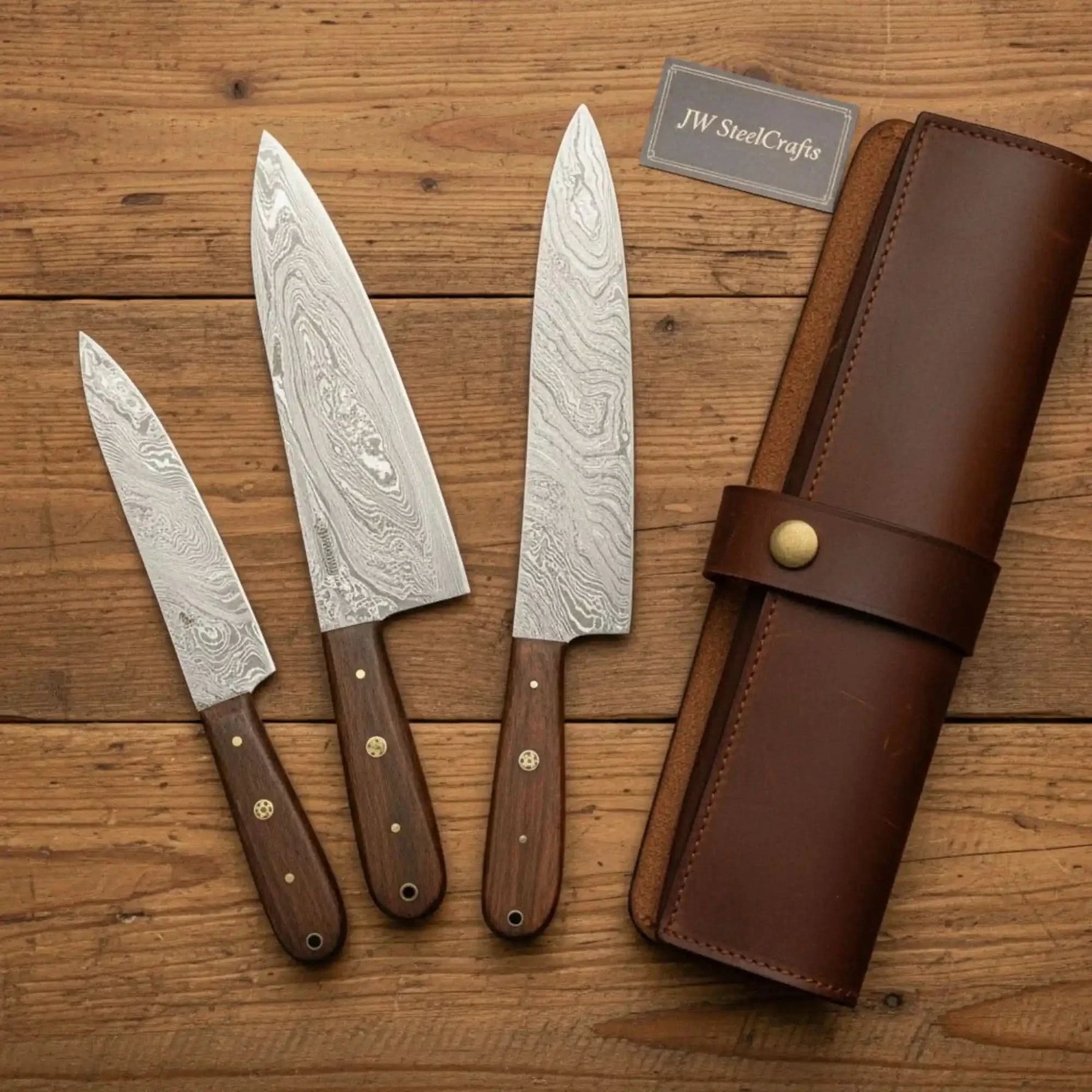 Handmade damascus steel knife with wood handle on dark surface