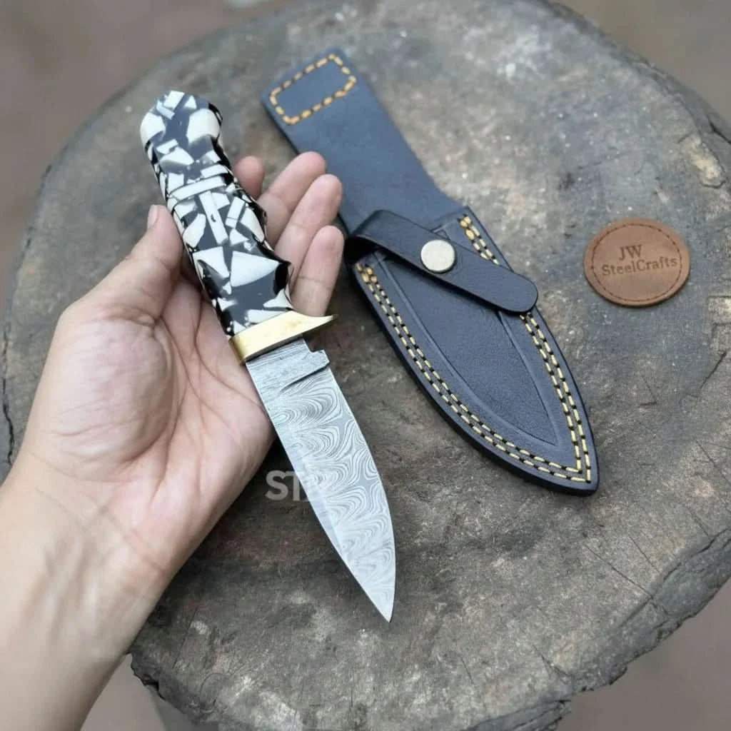 Handmade damascus steel knife with premium handle on dark surface