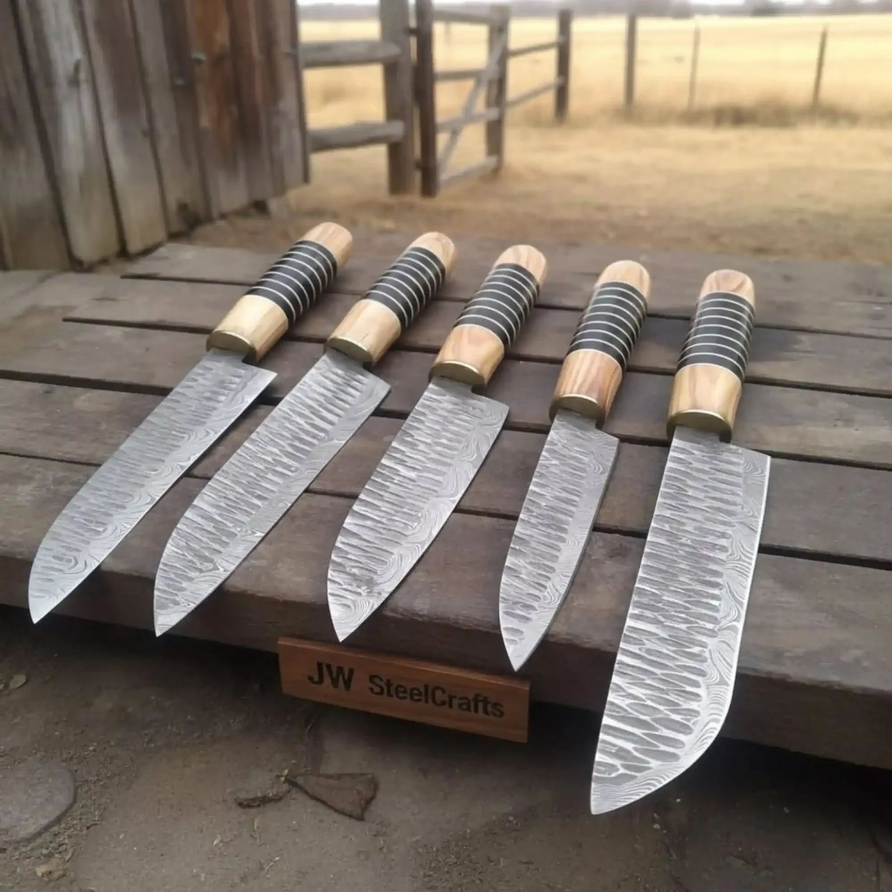 Handmade damascus steel knife with wood handle on dark surface