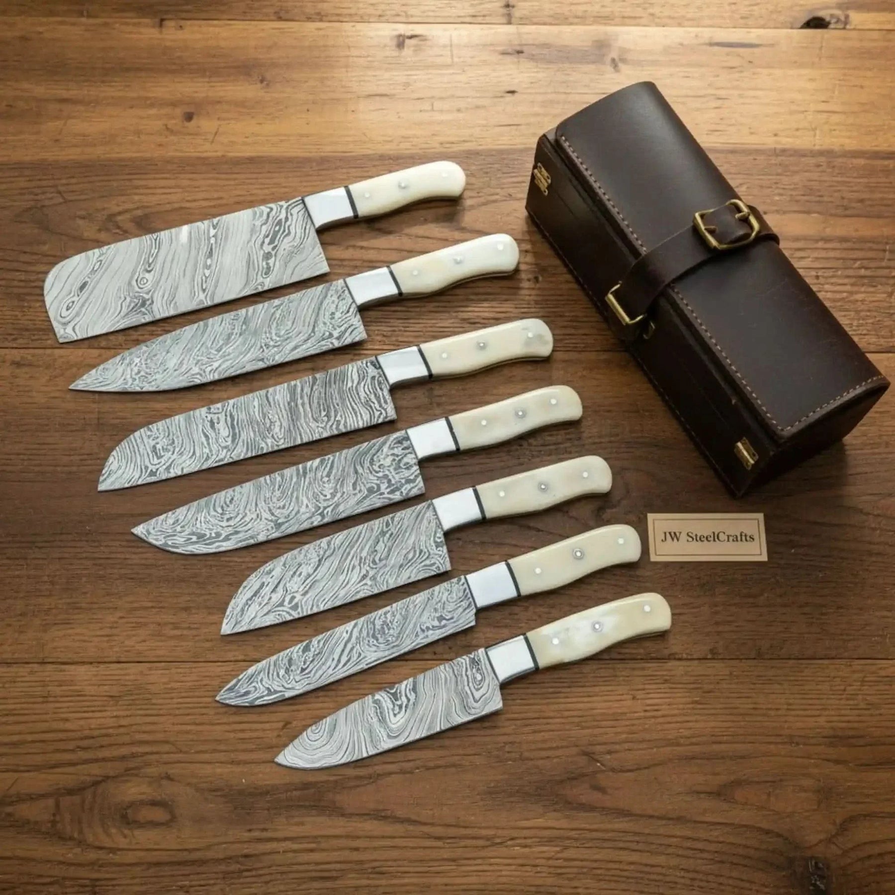 Handmade damascus steel knife with bone handle on dark surface