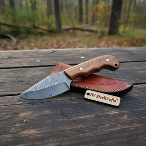 Handmade damascus steel knife with wood handle on dark surface