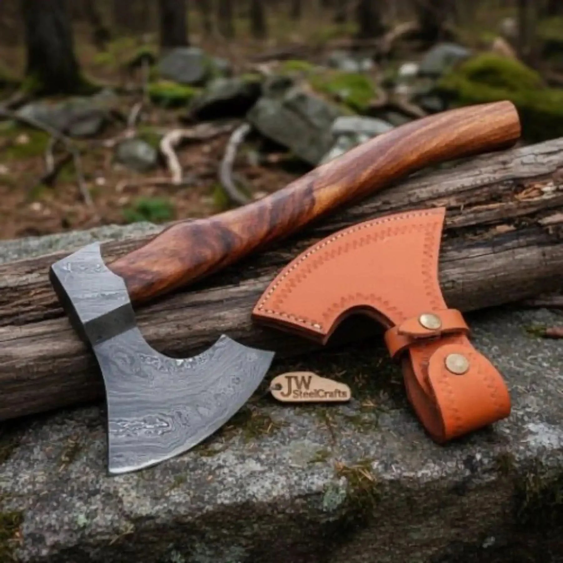 Damascus steel axe head with wood handle on rustic wood surface