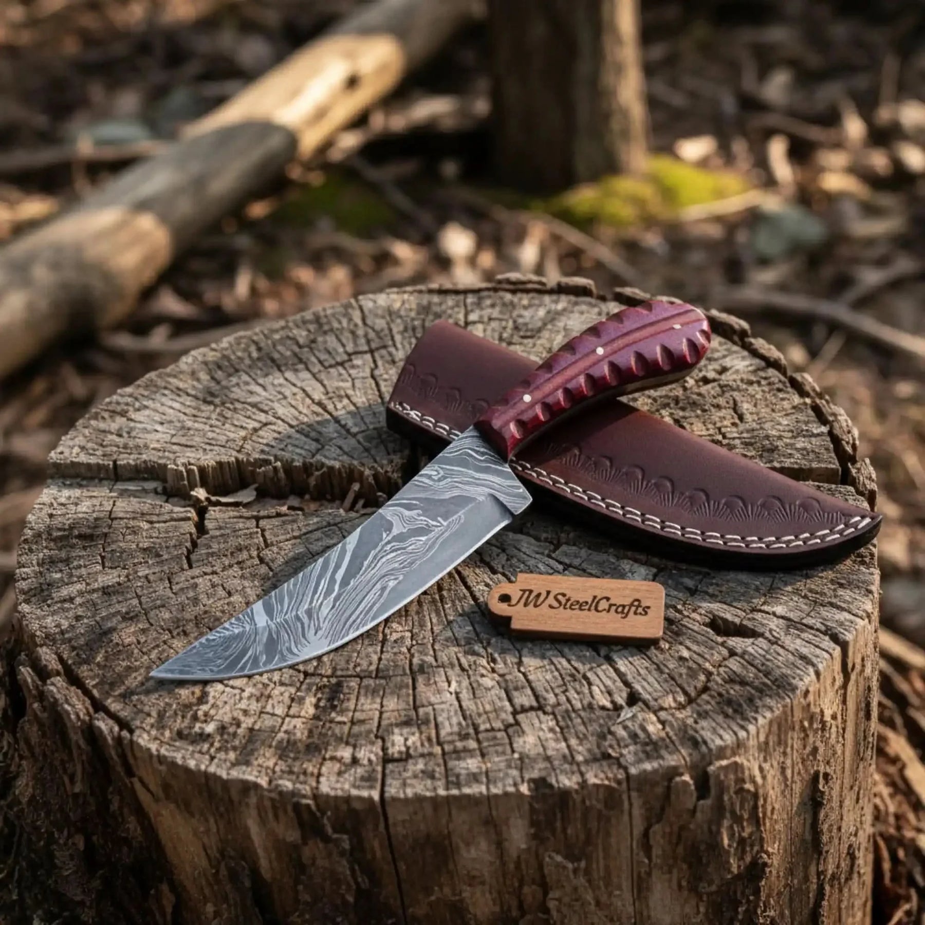 Handmade damascus steel knife with wood handle on dark surface