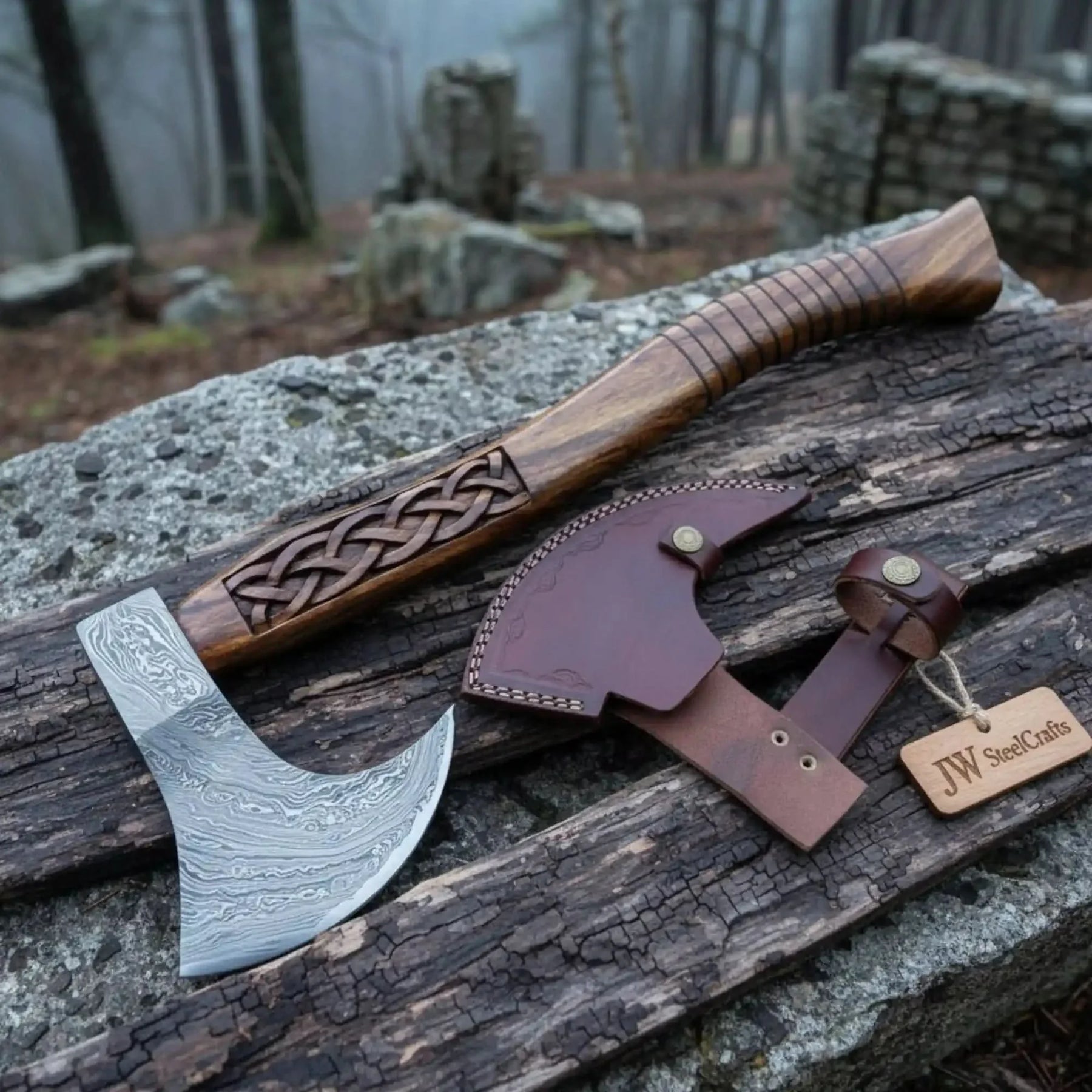 Damascus steel axe head with premium handle on rustic wood surface