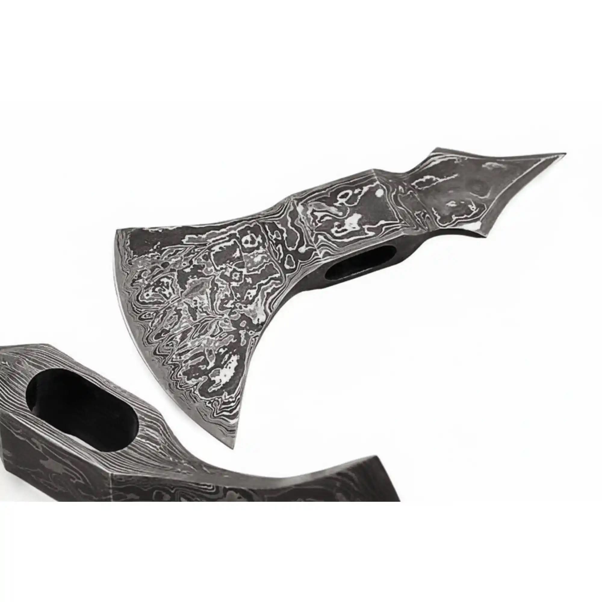 Damascus steel axe head with premium handle on rustic wood surface