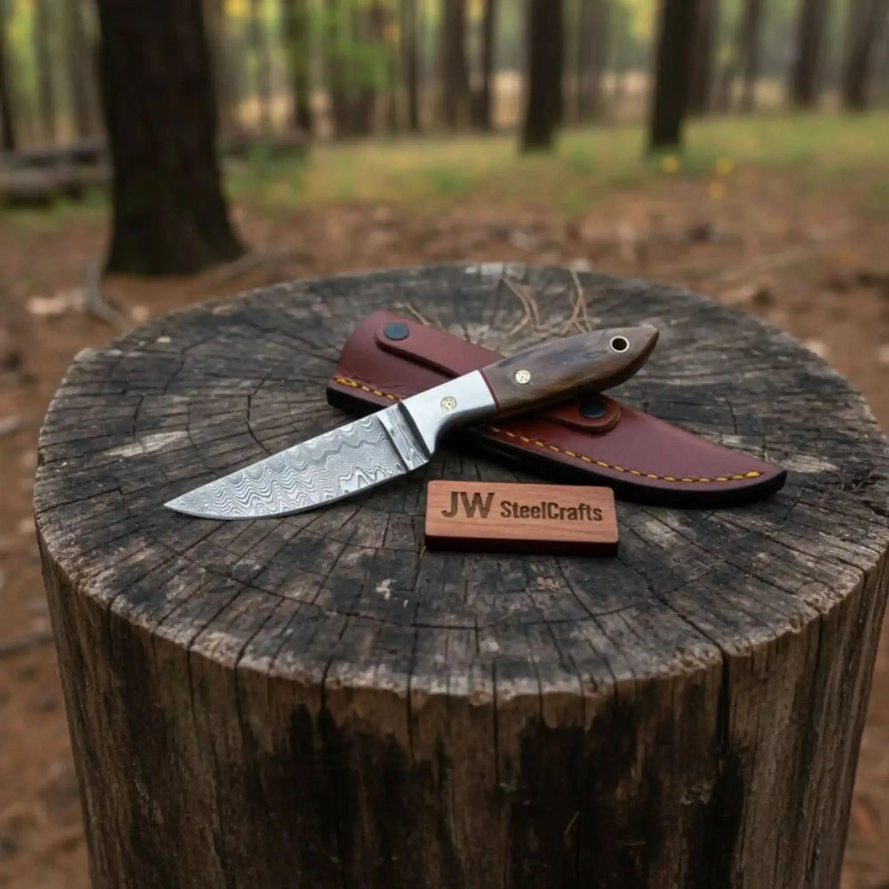 Handmade damascus steel knife with wood handle on dark surface