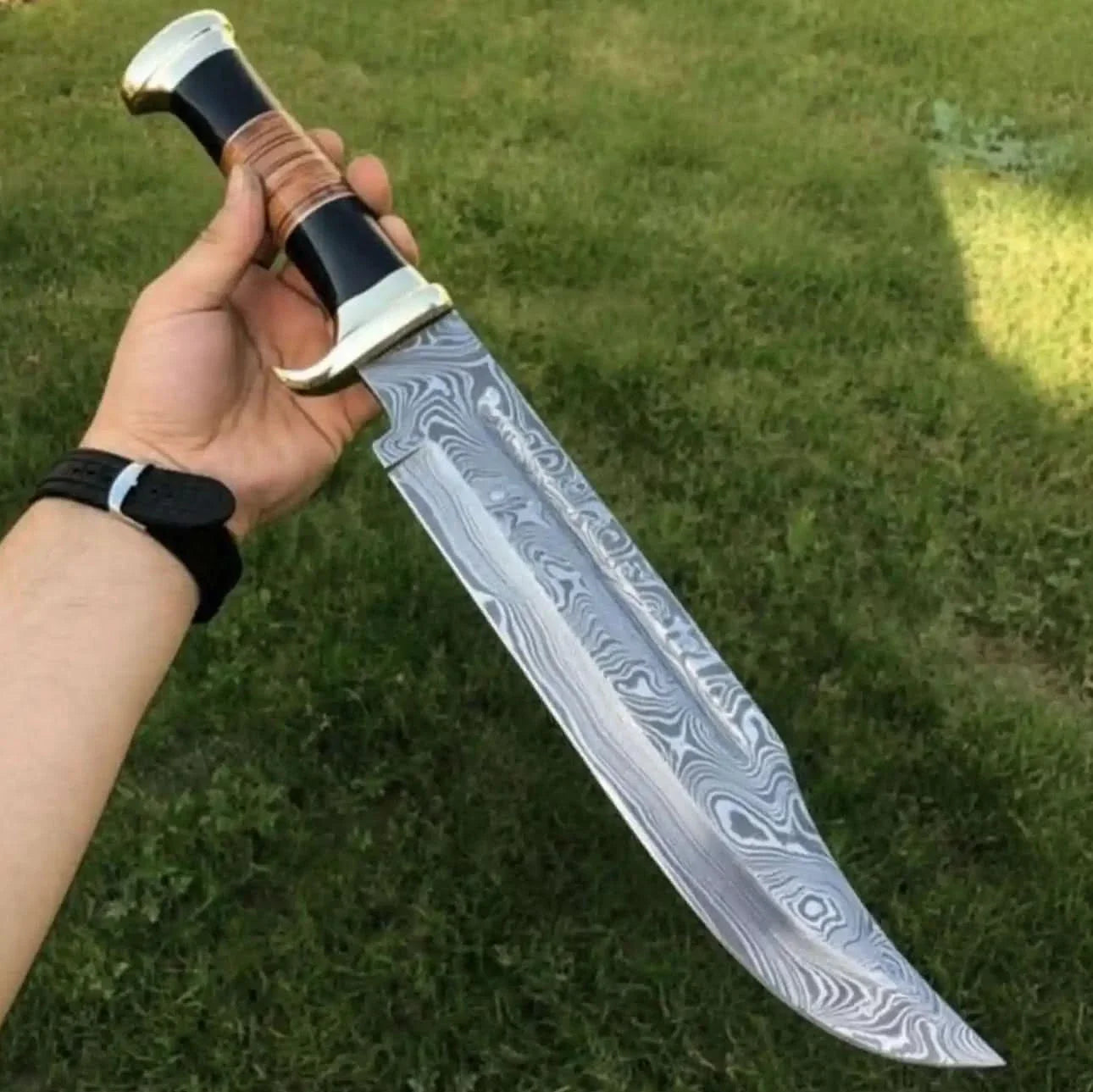 Handmade damascus steel knife with premium handle on dark surface